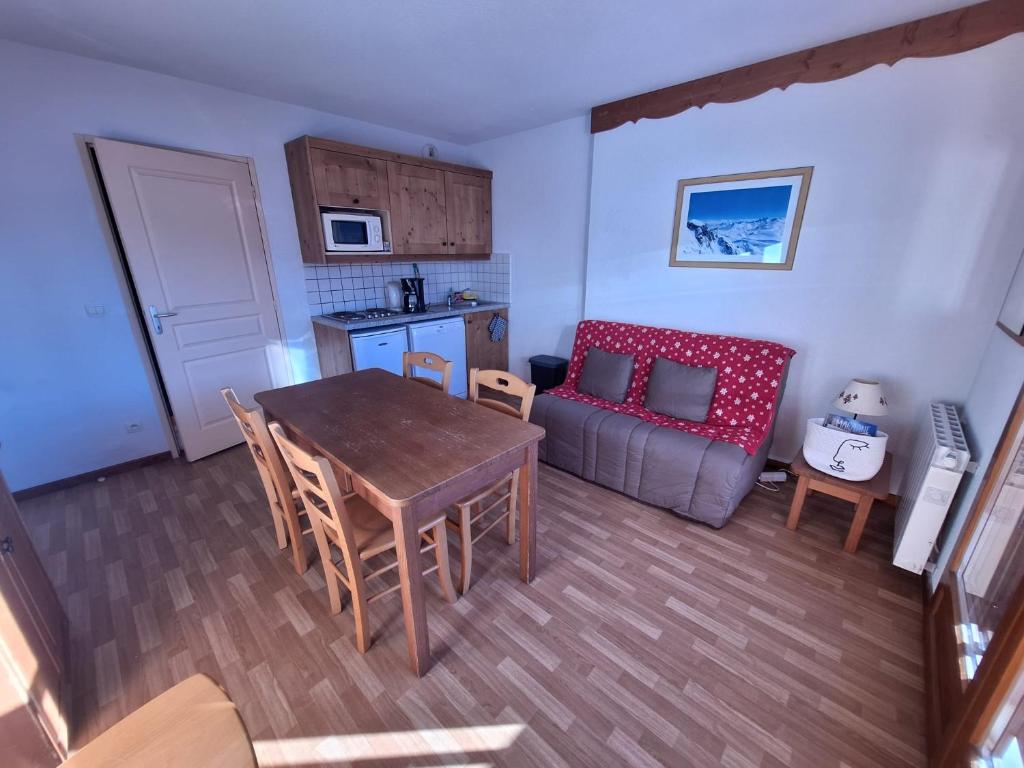 une cuisine et un salon avec une table et un canapé dans l'établissement Appartement en plein coeur du Queyras - Les Granges d'Arvieux, à Arvieux 4 autres photos