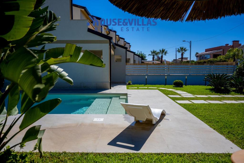 une chaise dans la cour d'une maison avec piscine dans l'établissement Villa Zuzana, à Calabernardo