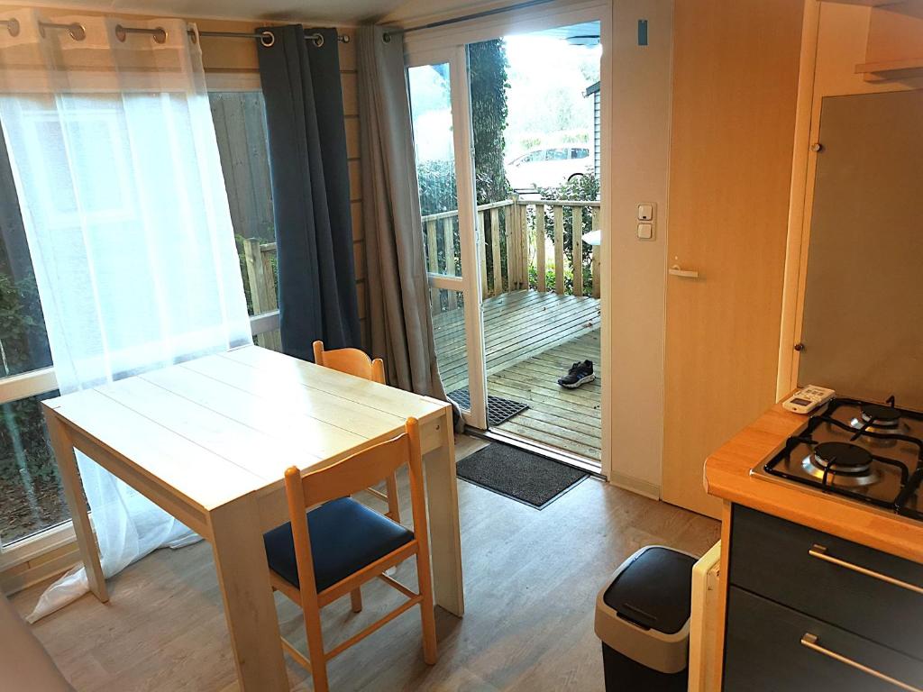 Il comprend une petite cuisine avec une table et un balcon. dans l'établissement Bungalow tout confort 2ch 5pers 400DJ, à La Boissière-de-Montaigu
