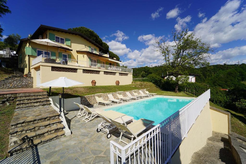 une maison avec une piscine à côté d'un bâtiment dans l'établissement Villa Collina Del Sole 12 Pax by VILLASRETREATS, à Nicola