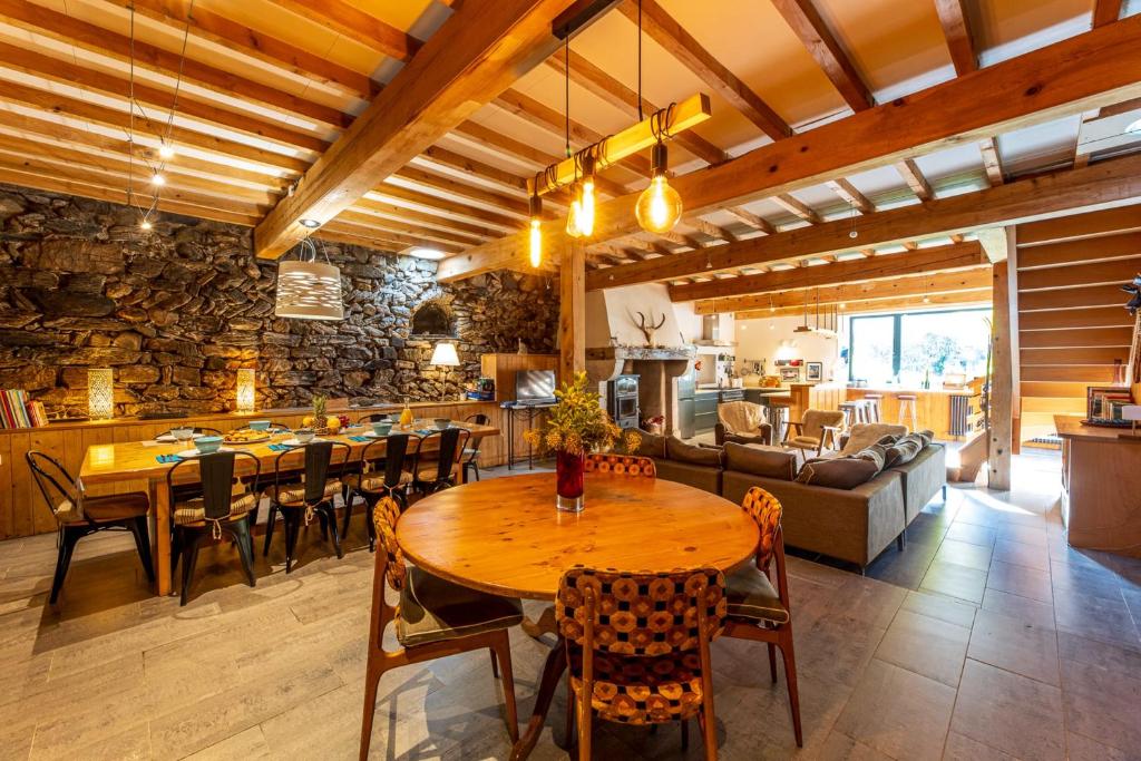 un salon avec une table, des chaises et un canapé dans l'établissement Grand gîte 4 étoiles - Bain nordique, à Aste-Béon