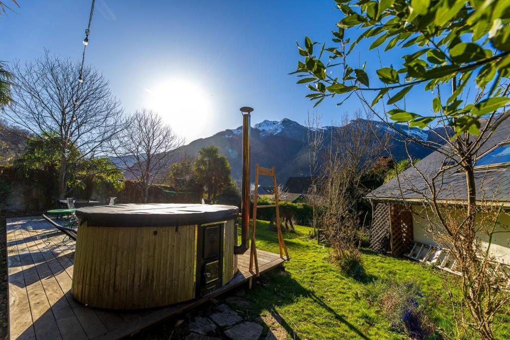un conteneur en bois sur une terrasse avec des montagnes en arrière-plan dans l'établissement Grand gîte 4 étoiles - Bain nordique, à Aste-Béon