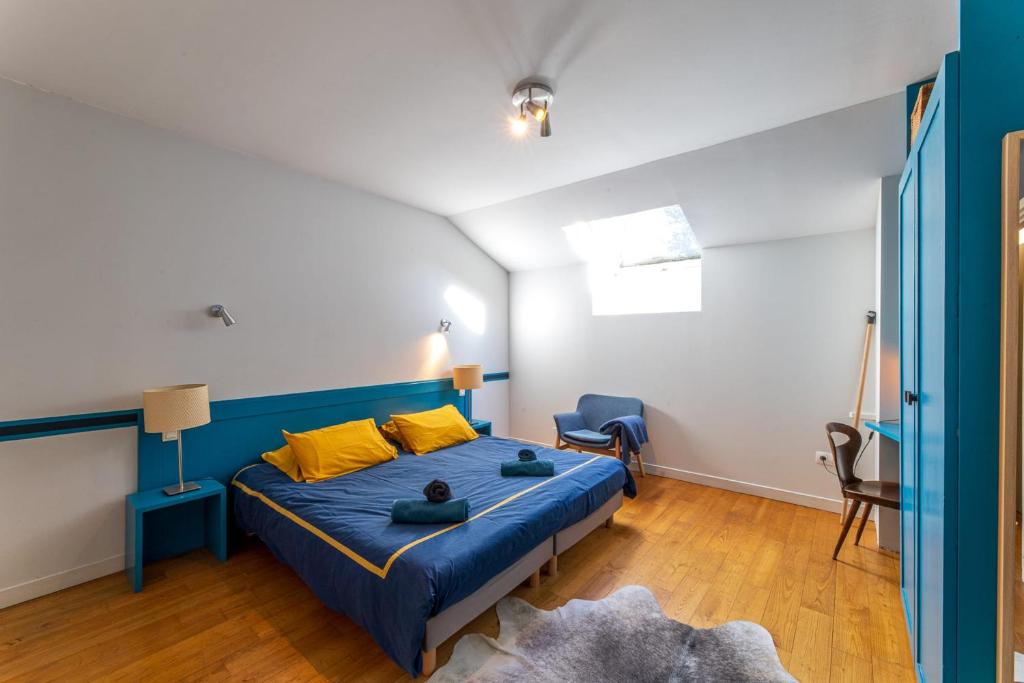 - une chambre avec un lit bleu et une chaise dans l'établissement Grand gîte 4 étoiles - Bain nordique, à Aste-Béon