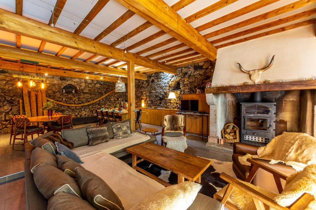 un salon avec un canapé et une cheminée dans l'établissement Grand gîte 4 étoiles - Bain nordique, à Aste-Béon