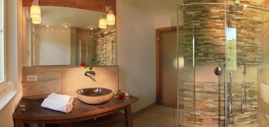 une salle de bain avec un lavabo et une douche dans l'établissement Überbacherhof, à Termeno