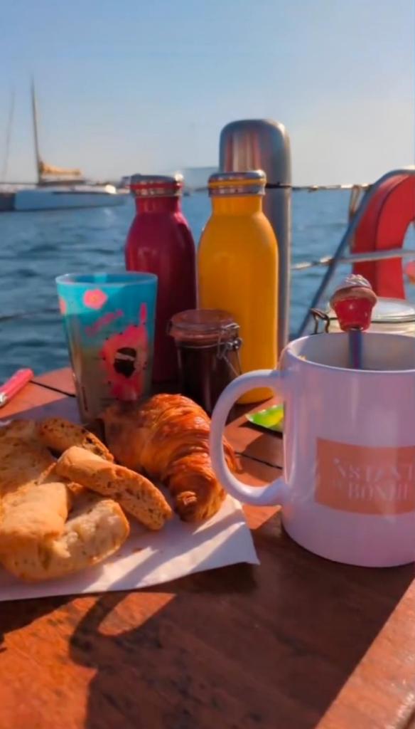 - une table avec une tasse de café et des pâtisseries dans l'établissement stlocavoile 2, Seuls à bord d un voilier, à Porto-Vecchio