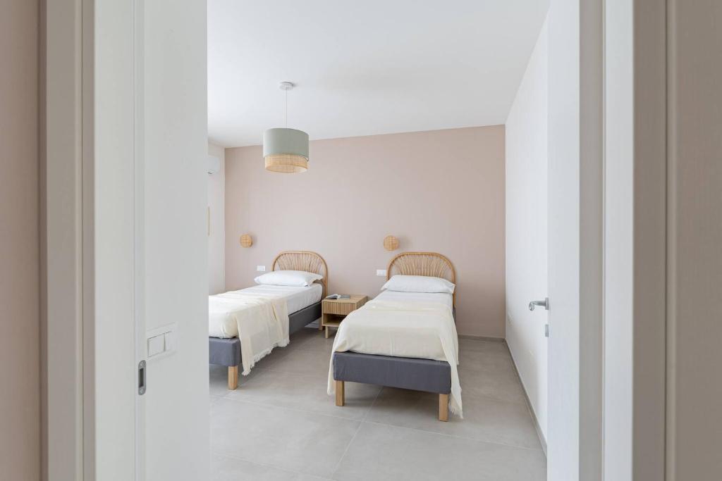 deux lits dans une chambre aux murs blancs dans l'établissement Villa Novelli - YourPlace Abruzzo, à Fossacesia
