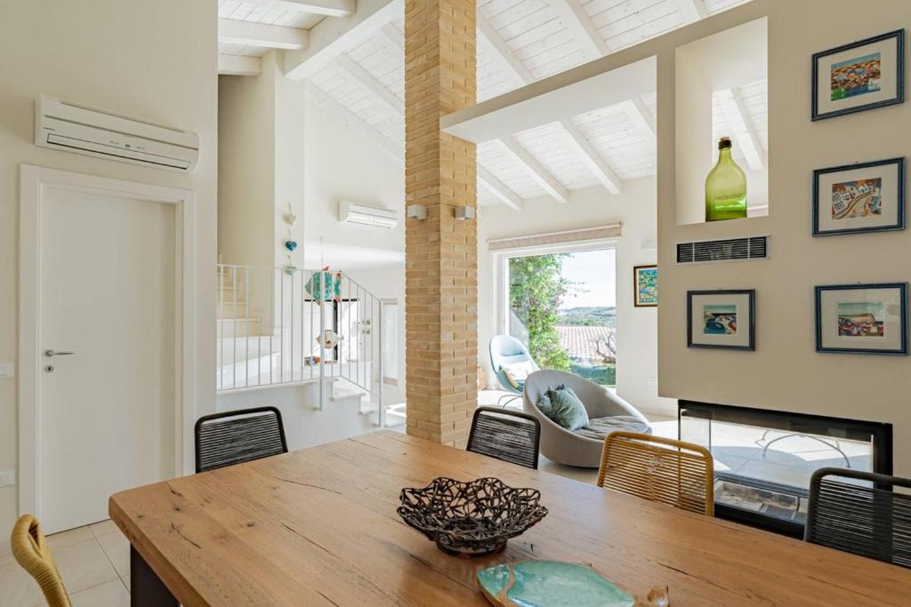 une salle à manger avec une table et une cheminée dans l'établissement Villa dei Gruccioni - YourPlace Abruzzo, à Torino di Sangro