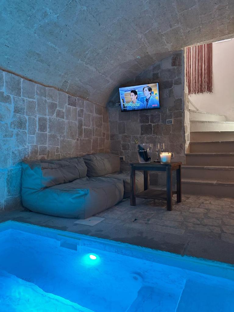 - un salon avec un canapé et une table à côté de la piscine dans l'établissement Midi Pool Villa & SPA, à Veglie