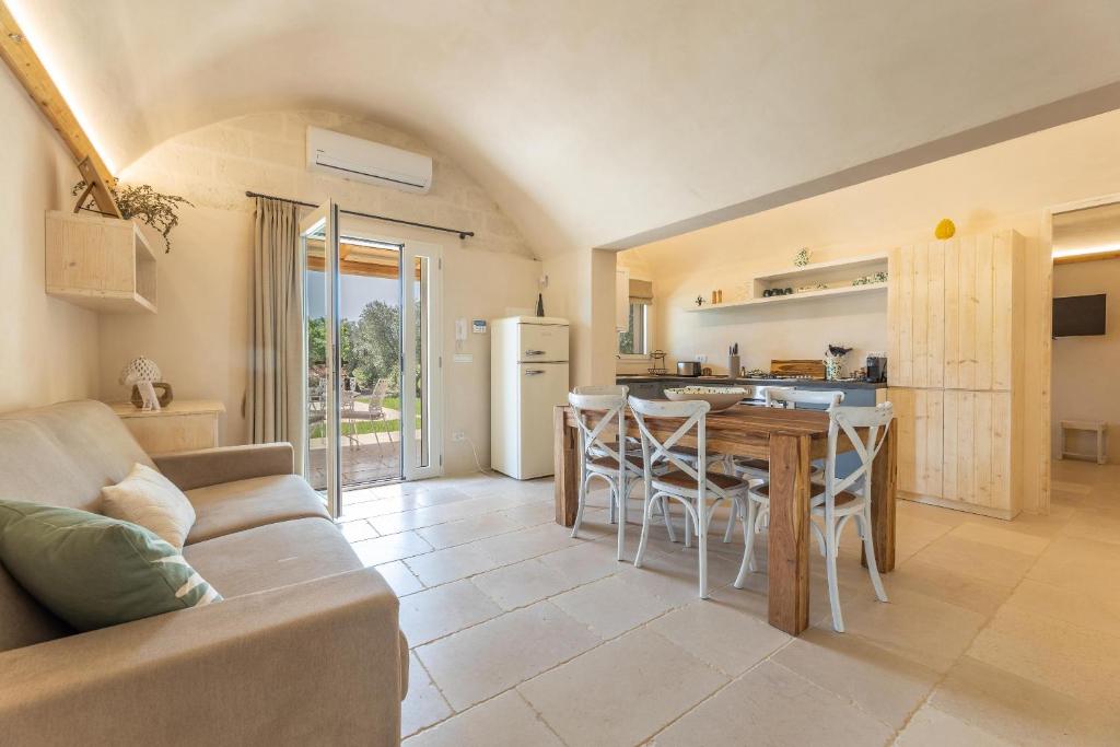 une cuisine et un salon avec une table et des chaises dans l'établissement Villa Violetta, à Ostuni