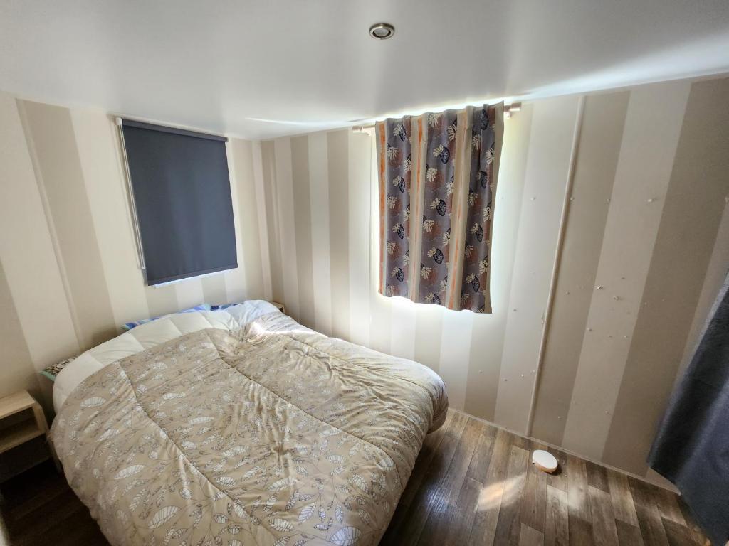 une petite chambre avec un lit et une fenêtre dans l'établissement Camping poney, à Sainte-Croix-de-Verdon
