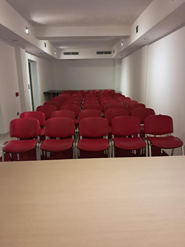 une salle de conférence vide avec des chaises rouges à l'intérieur dans l'établissement Hotel Palace Gioia Tauro, à Gioia Tauro