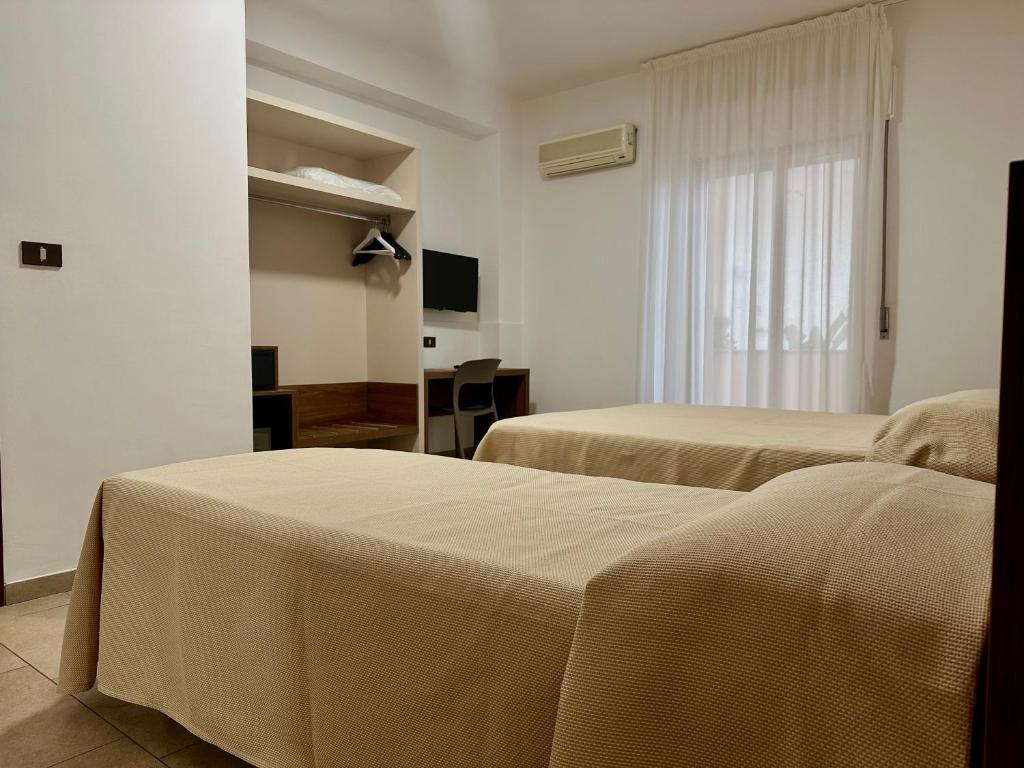 une chambre d'hôtel avec deux lits et une fenêtre dans l'établissement Hotel Soleado, à Taormine