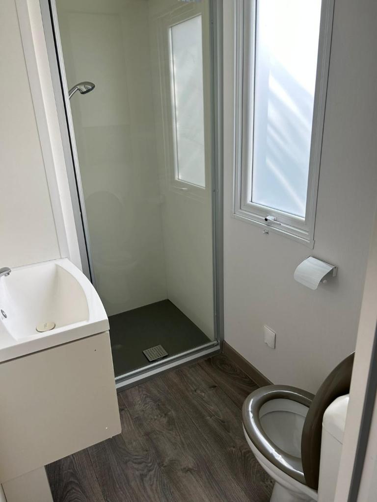 une salle de bain avec toilettes, lavabo et fenêtre dans l'établissement Azur 77, à Fréjus 6 autres photos