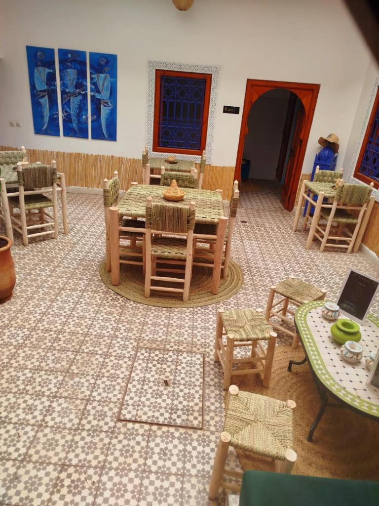 un salon avec une table et des chaises ainsi qu'une chambre avec une table et des chaises dans l'établissement Riad Bab Lakhmiss, à Marrakech 23 autres photos