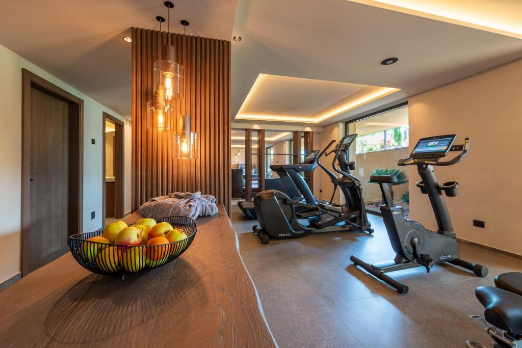 - une salle de sport avec un bol de fruits et des vélos d'exercice dans l'établissement Überbacherhof, à Termeno