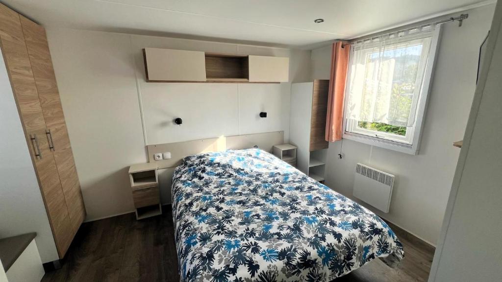une chambre avec un lit avec une couverture bleue et blanche dans l'établissement Détente et nature au bord du Rhône, à Condrieu