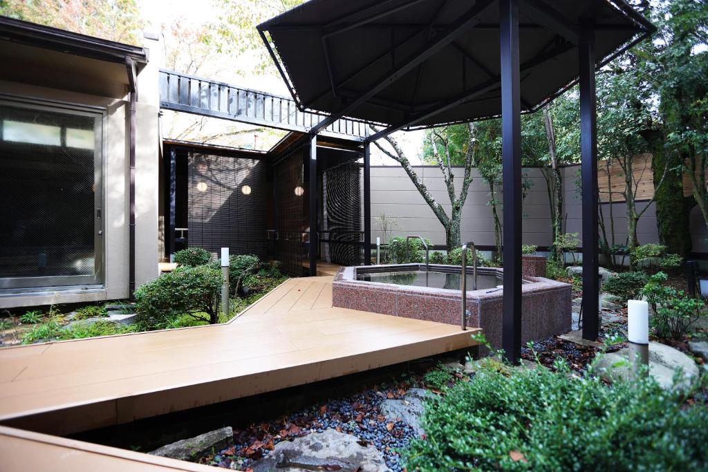 - un jardin avec une terrasse en bois et un parasol dans l'établissement Manten no Tsujinoya, à Komatsu