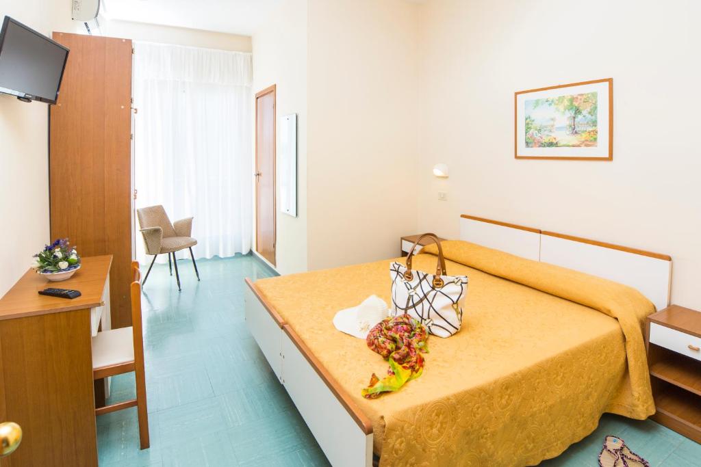 Cette chambre d'hôtel dispose d'un lit avec un porte-monnaie. dans l'établissement Hotel Garden, à Riccione