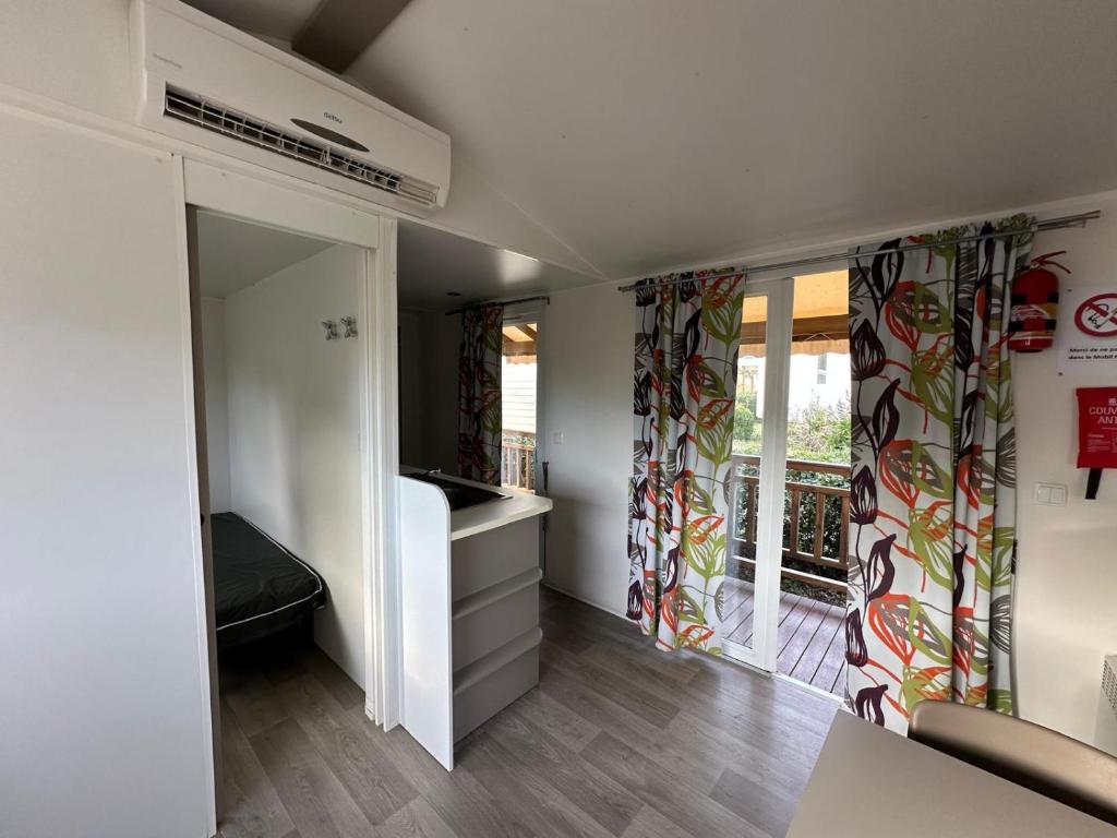 - un salon avec une fenêtre et des rideaux dans l'établissement Bungalow 4-6 personnes, à Lattes