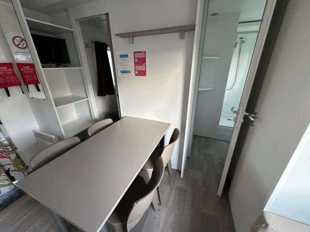 - une salle de réunion avec une table et des chaises blanches dans l'établissement Bungalow 4-6 personnes, à Lattes