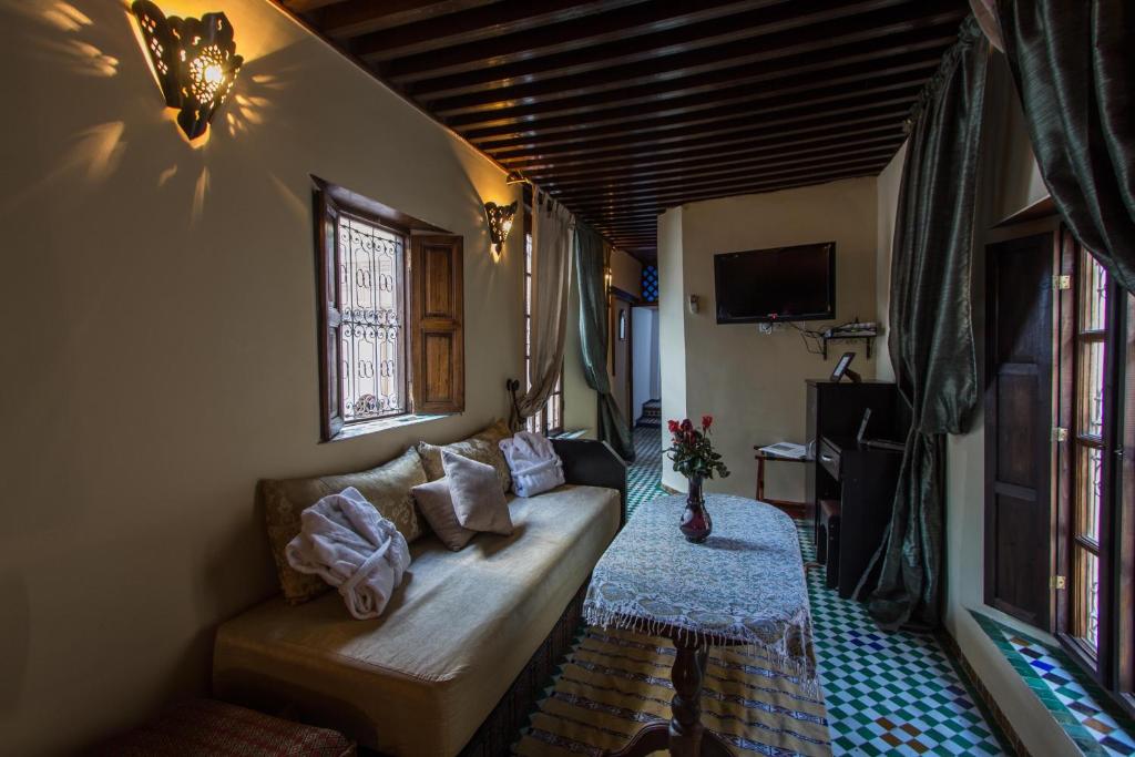 un salon avec un canapé et une table dans l'établissement Riad Les Remparts De Fès, à Fès