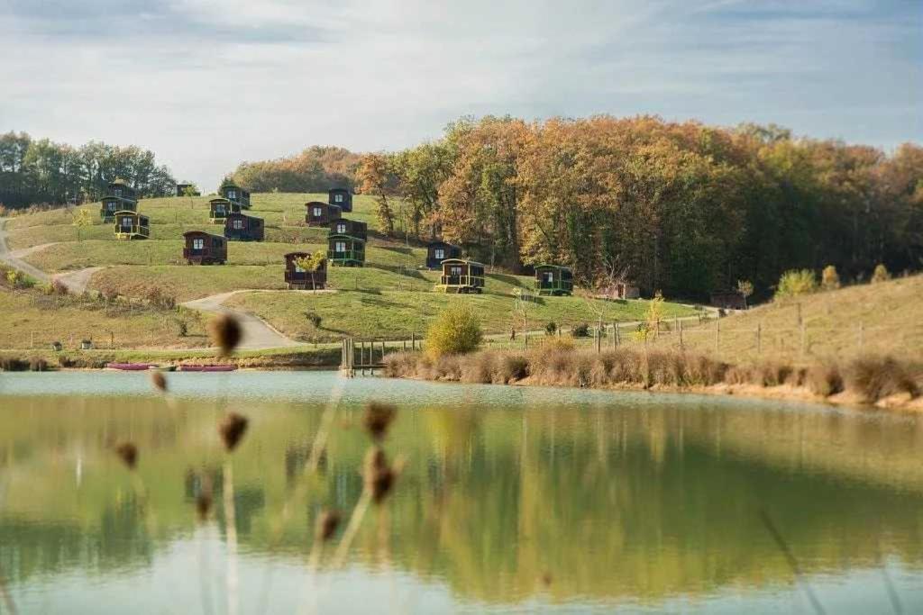 un groupe d’animaux debout à côté d’une masse d’eau dans l'établissement Camping 4 étoiles - Piscine - eed0aa, à Estipouy
