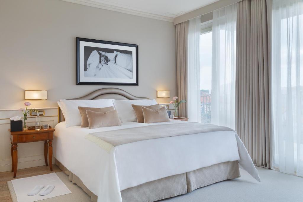 une chambre blanche avec un grand lit et une fenêtre dans l'établissement Grand Hotel Imperiale, à Forte dei Marmi 101 autres photos
