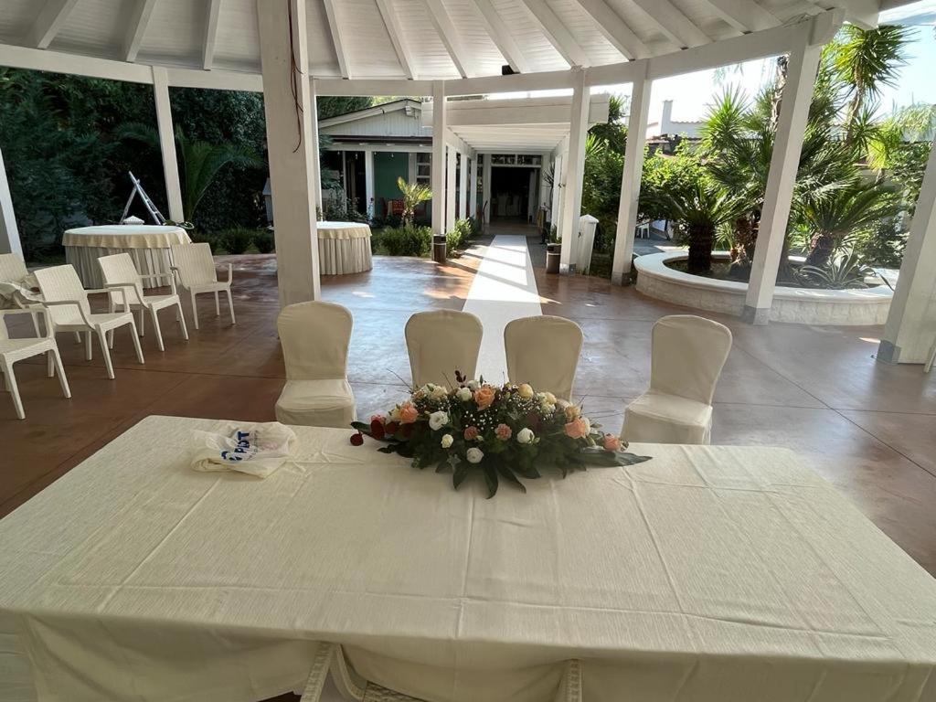 d'une table et de chaises blanches avec une composition florale. dans l'établissement Hotel Borina by Isola dei sapori, à Foce Varano 43 autres photos