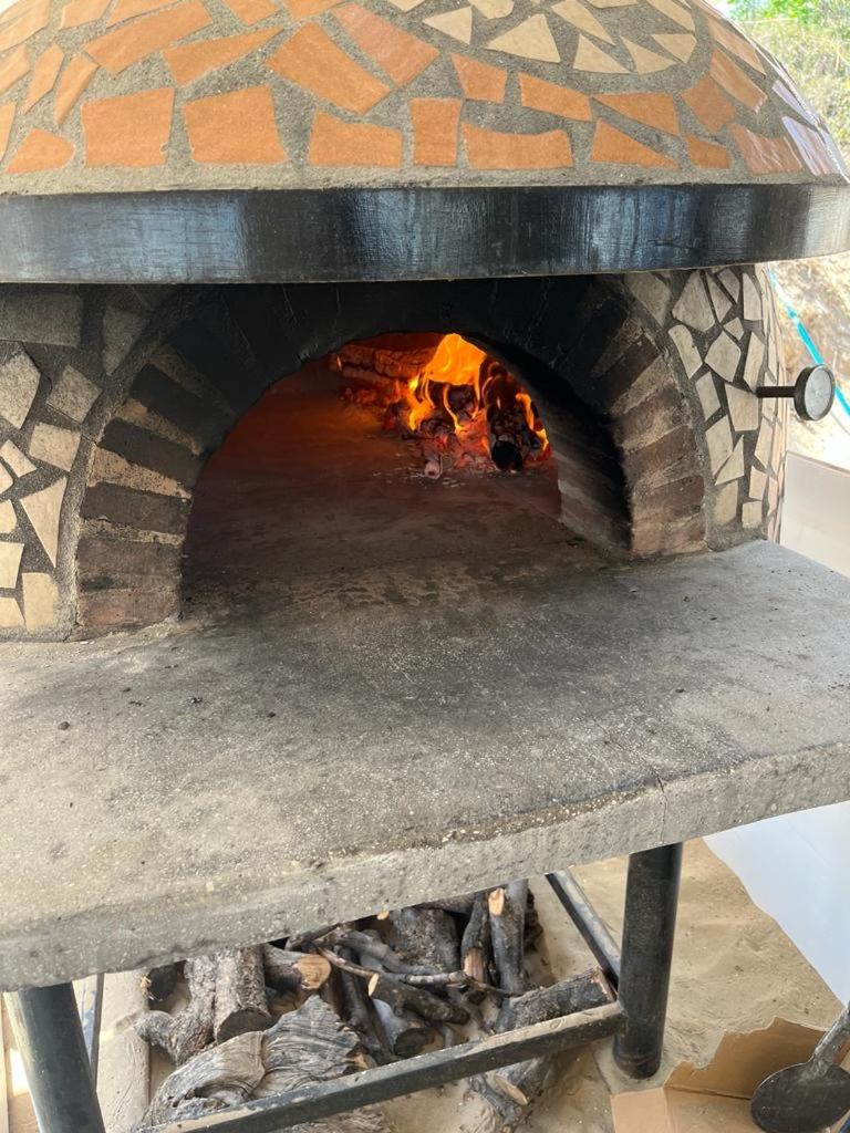 un four en briques avec une cheminée à l'intérieur dans l'établissement Hotel Borina by Isola dei sapori, à Foce Varano