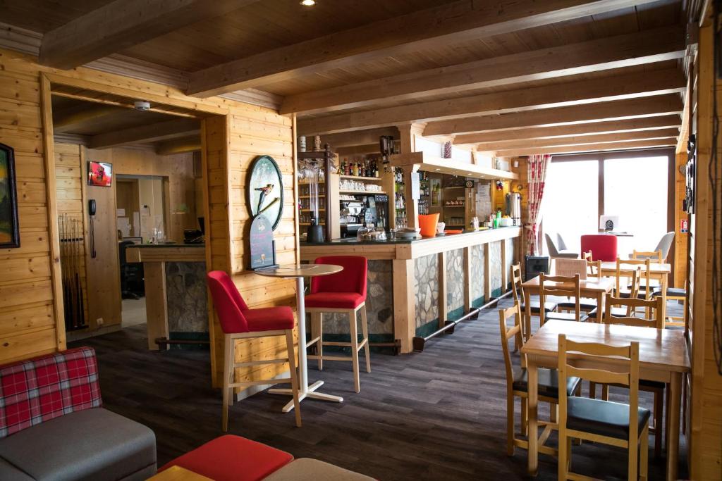 - un restaurant avec du parquet, des chaises et des tables rouges dans l'établissement Hotel Emeraude, à Peisey-Nancroix 37 autres photos