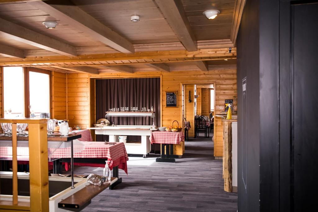 d'une salle à manger avec des murs en bois et du parquet. dans l'établissement Hotel Emeraude, à Peisey-Nancroix