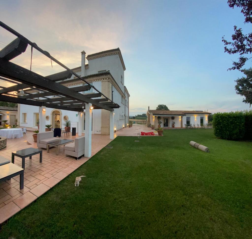 une arrière-cour avec une terrasse et une pelouse dans l'établissement Moliké country house, à Giulianova
