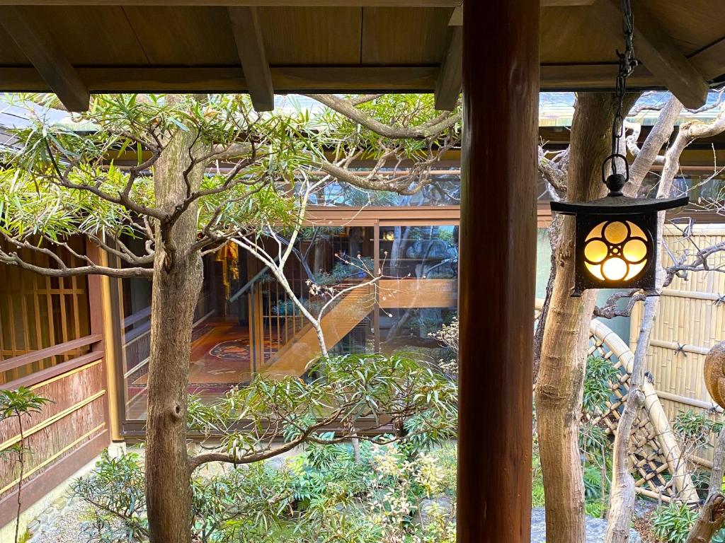 une lumière suspendue à une véranda avec un arbre dans l'établissement Muromachi Yutone Kyokoyado, à Kyoto