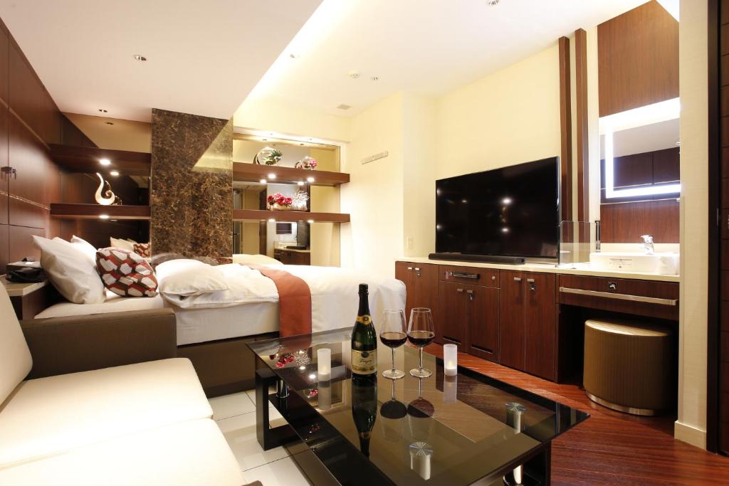 un salon avec un lit et un canapé dans l'établissement Hotel Moana Shinjuku (Adult Only), à Tokyo