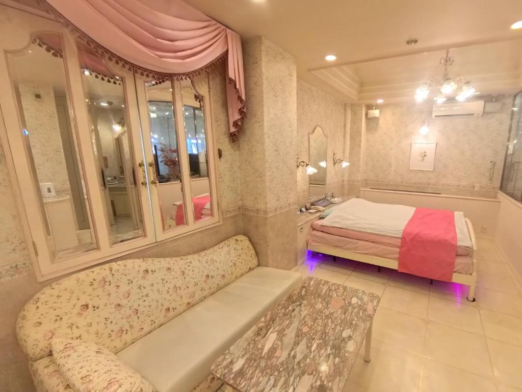 une chambre avec un lit et un canapé dans l'établissement ホテル ニューパレス, à Amagasaki 3 autres photos