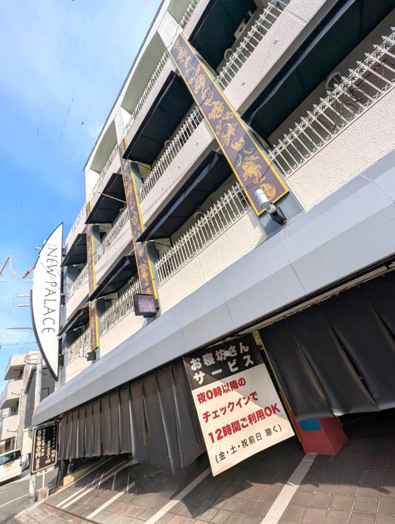 un bâtiment avec une enseigne sur le côté dans l'établissement ホテル ニューパレス, à Amagasaki