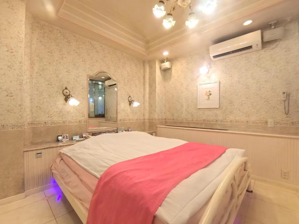 une chambre avec un grand lit et un miroir dans l'établissement ホテル ニューパレス, à Amagasaki