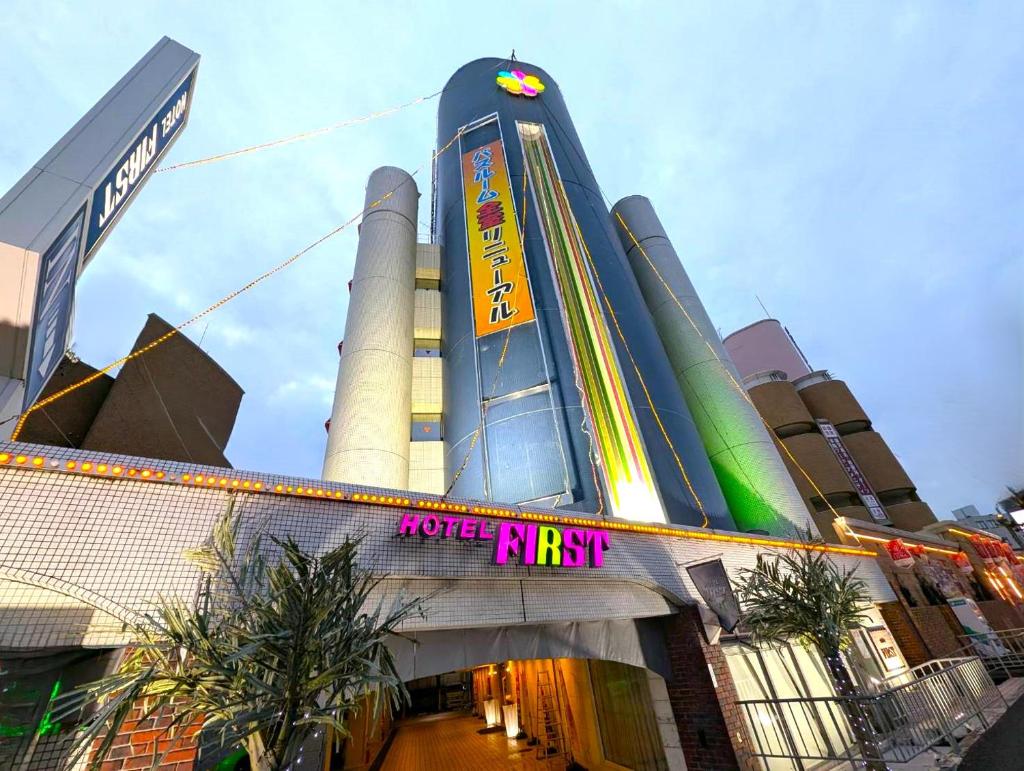 un bâtiment avec une enseigne devant lui dans l'établissement Hotel First (Adult Only), à Ikeda