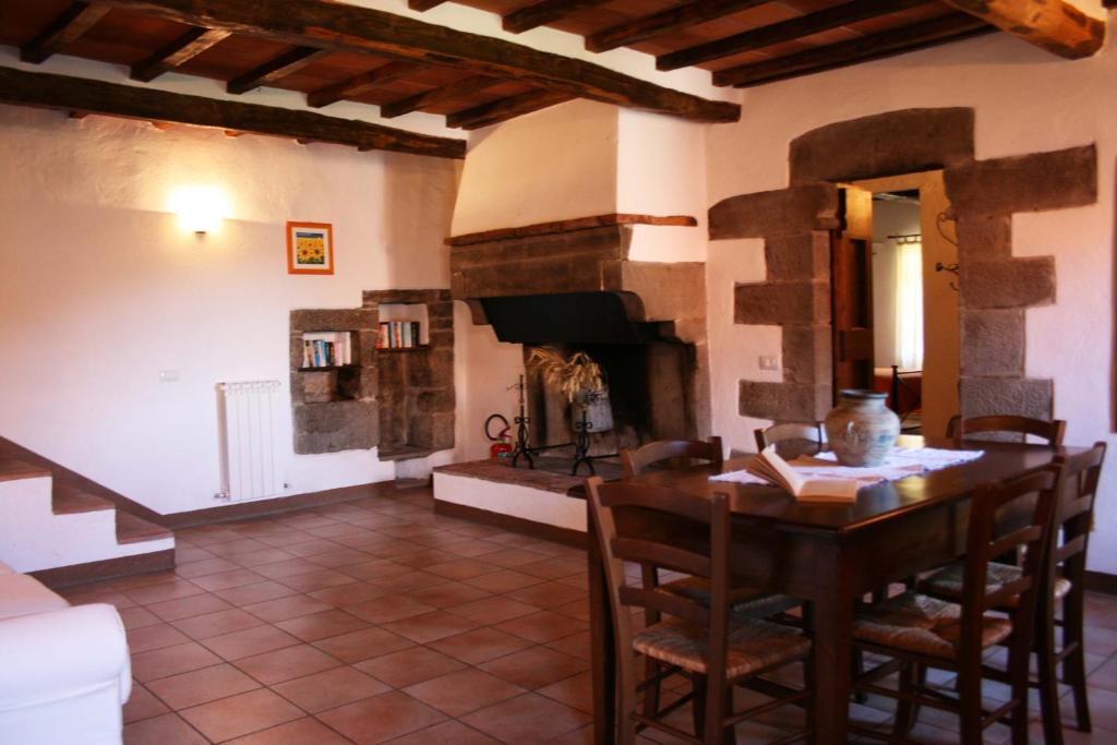un salon avec une table et une cheminée dans l'établissement Borgo Antico, à Poggioni