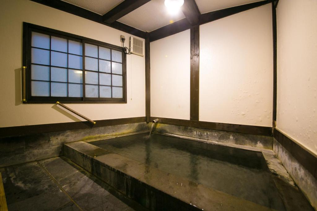 une chambre vide avec une piscine d'eau dans l'établissement Kinosato Yamanoyu, à Kokonoe