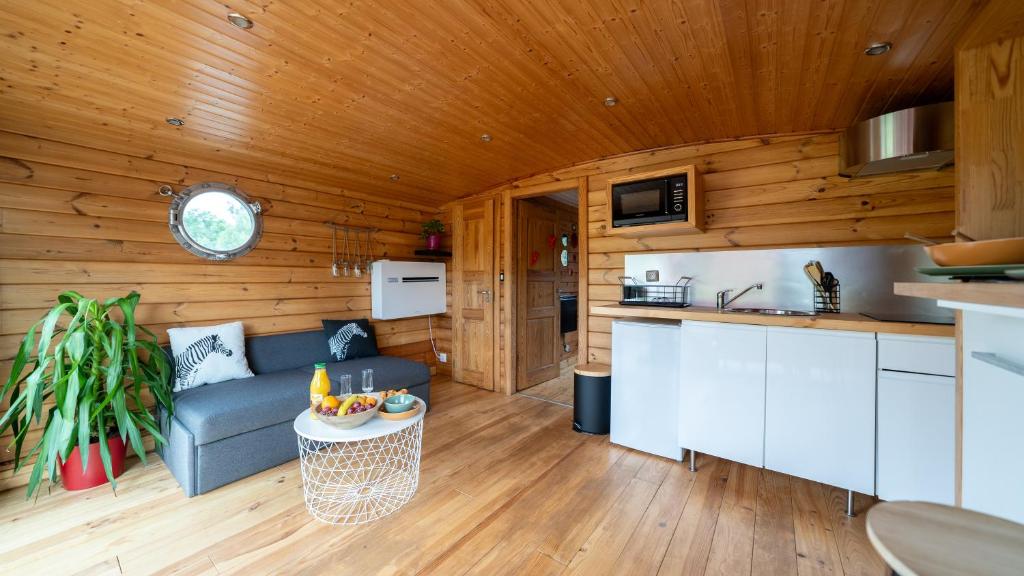 une cuisine et un salon avec un canapé et une table dans l'établissement Village Toue du Domaine des Demoiselles, à Chassenard