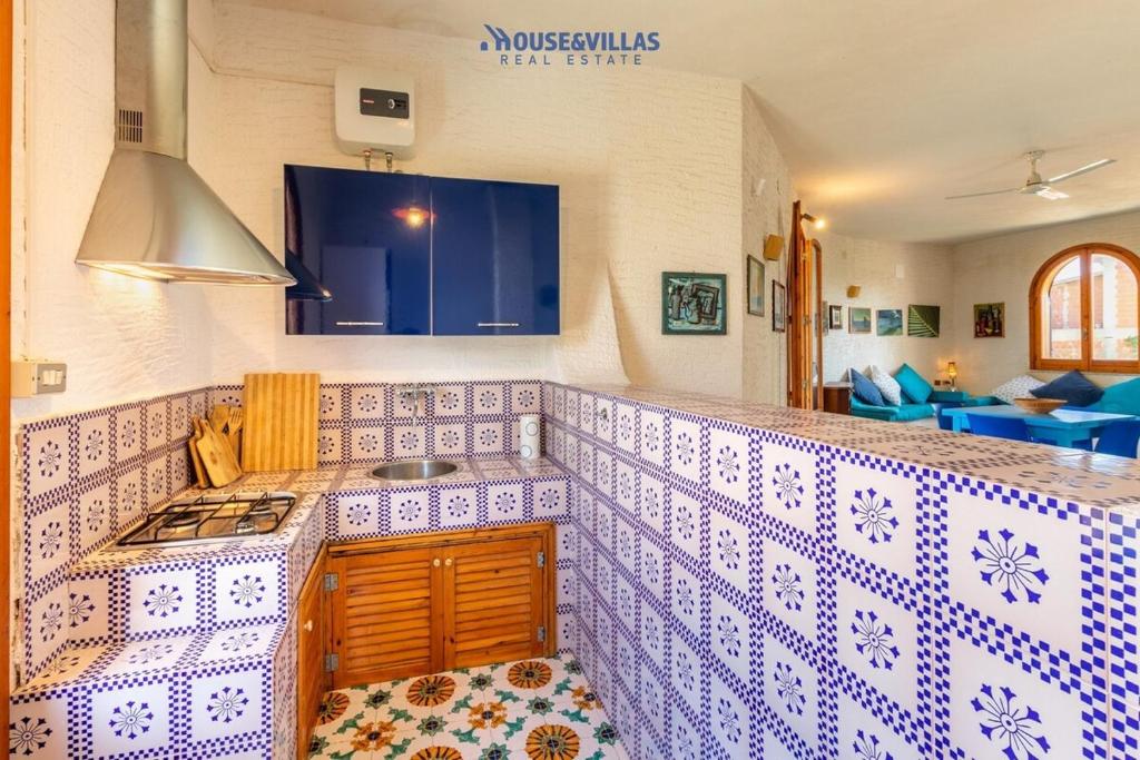 - une cuisine avec un comptoir en carrelage bleu et blanc dans l'établissement House&Villas - Villa le Palme di Vendicari, à Noto