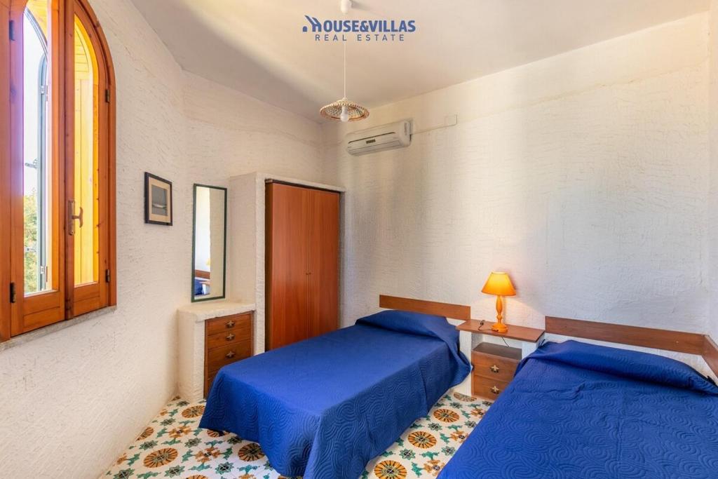 une chambre avec deux lits et un bureau et une fenêtre dans l'établissement House&Villas - Villa le Palme di Vendicari, à Noto