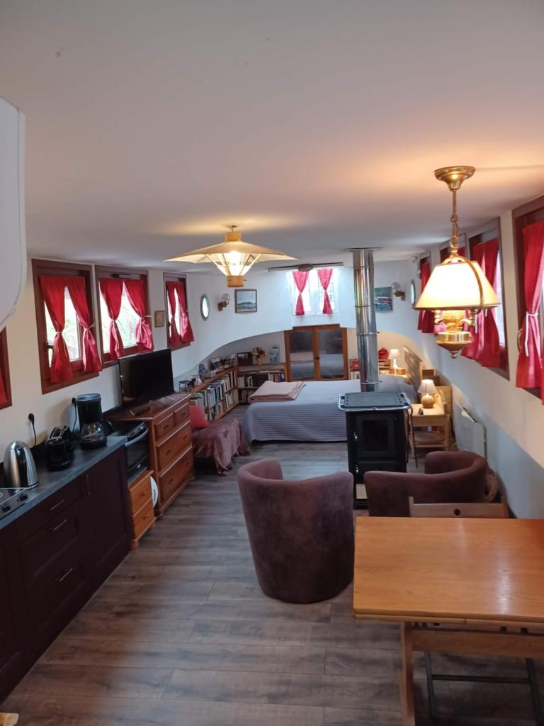 une chambre d'hôtel avec un lit, une table et des chaises dans l'établissement Sur la Somme à bord de la péniche Arche de Noé, à Pont-Rémy