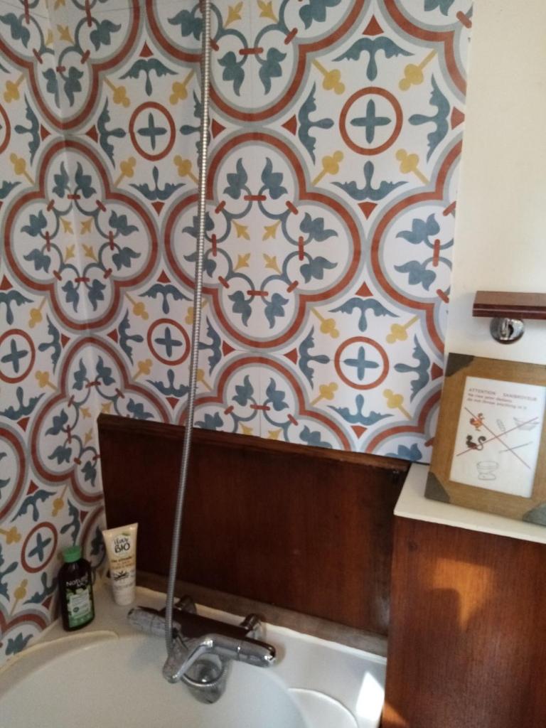 La salle de bains est pourvue d'un lavabo et d'un mur en carrelage. dans l'établissement Sur la Somme à bord de la péniche Arche de Noé, à Pont-Rémy