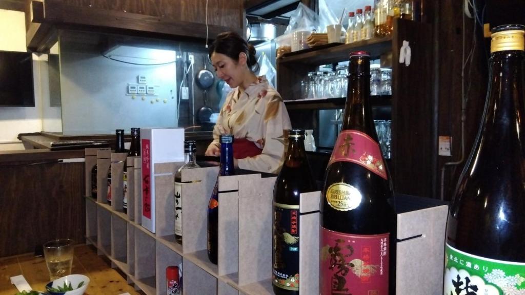une femme dans une cuisine préparant des bouteilles de vin dans l'établissement 温泉屋ひろすけ旅館, à Fukushima