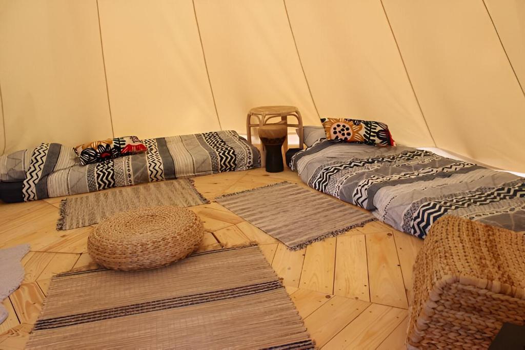 une chambre avec des tapis et des tapis dans une tente dans l'établissement Le Val Insolite, à Lieuron