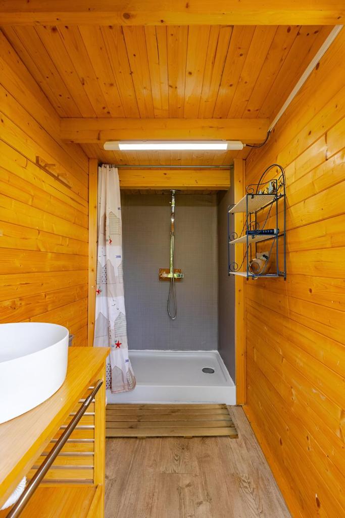 une salle de bain avec une baignoire et un lavabo dans une pièce dans l'établissement Le Val Insolite, à Lieuron