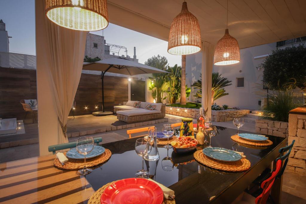une terrasse avec une table et des verres à vin. dans l'établissement Nilu al Mare - Villa pool & sea Monopoli, à Monopoli